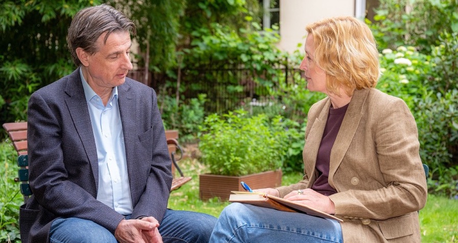 Claudia Mächtle im Gespräch mit Klient im Garten